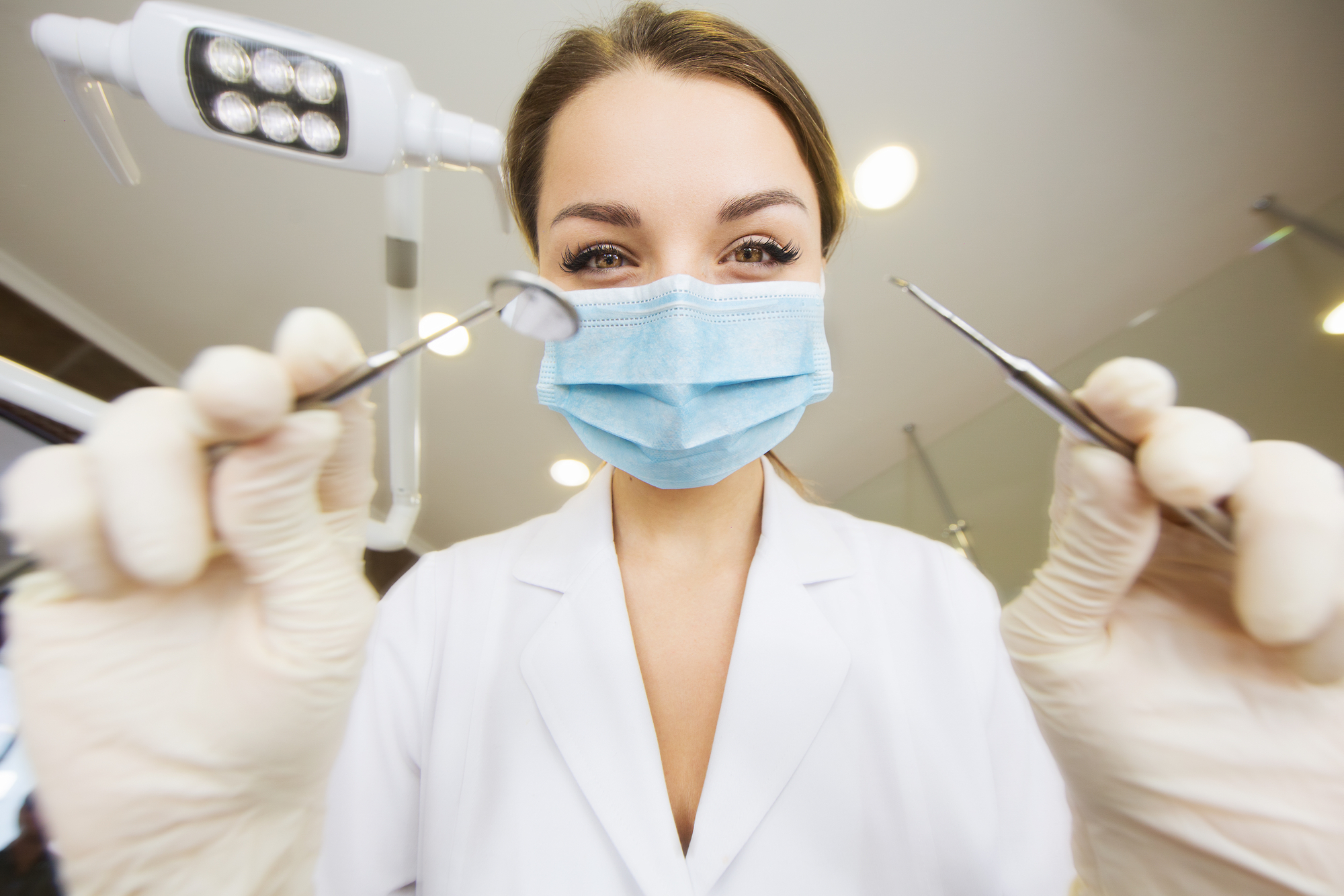 Стоматолог в перчатках с инструментом
